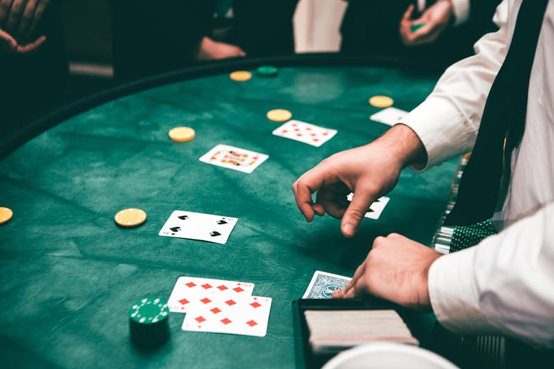 Dealer's hands laying cards on a green blackjack table